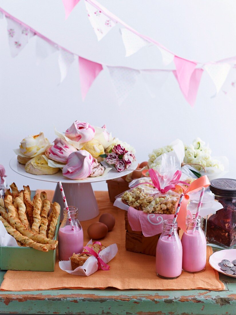 Sweet and savoury snacks and strawberry milkshake on buffet table