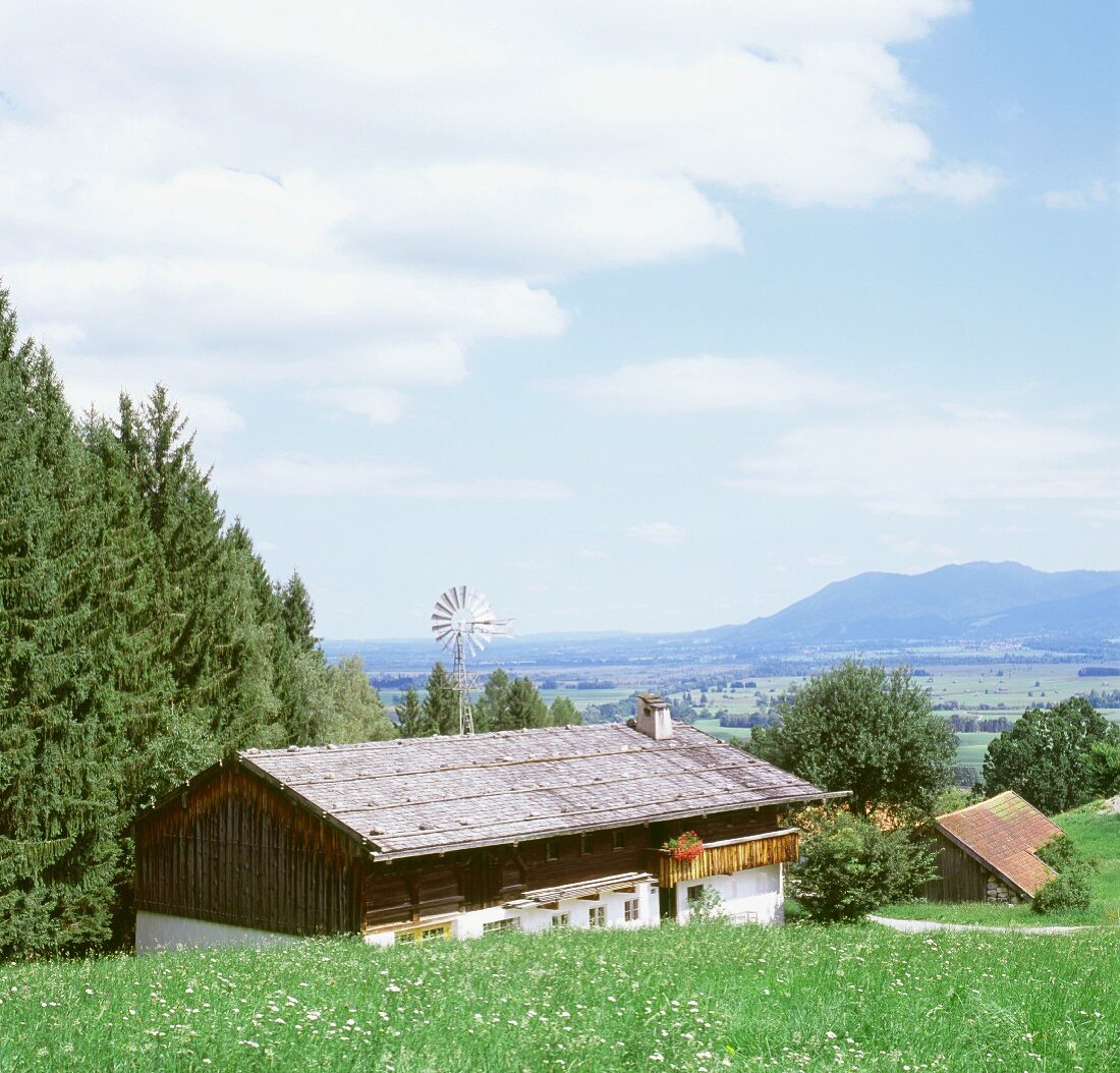 Blick auf einen Bauernhof und auf die dahinter liegende Landschaft