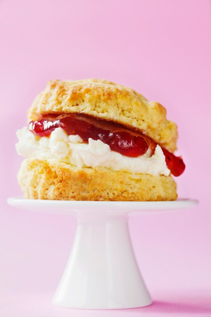 Scone mit Clotted Cream und Erdbeermarmelade auf einem Mini-Kuchenständer