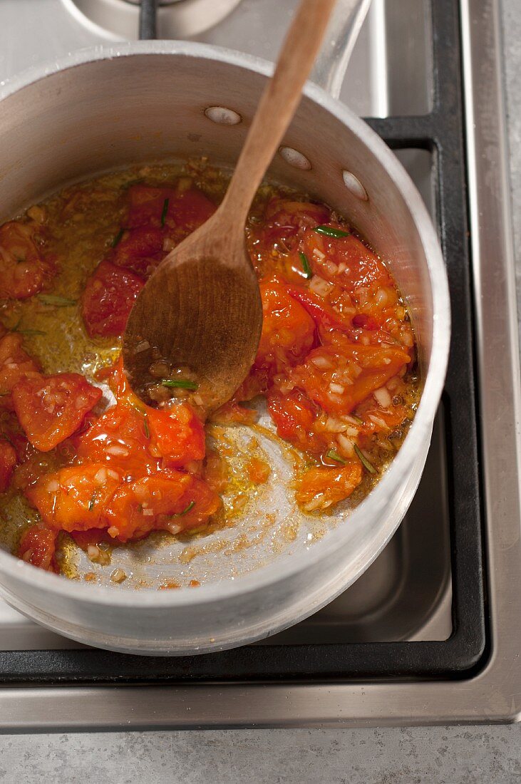 Tomatoes being fried in a pot