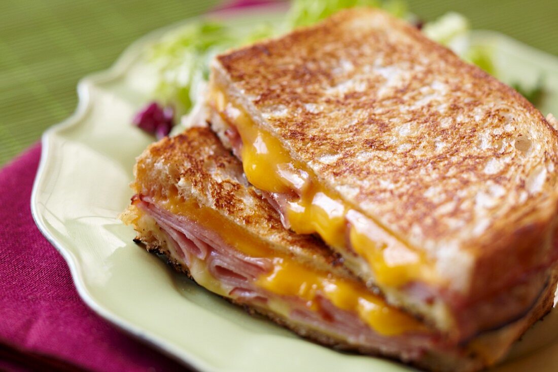 Grilled Ham and Cheese Sandwich; Halved and Stacked on a Plate