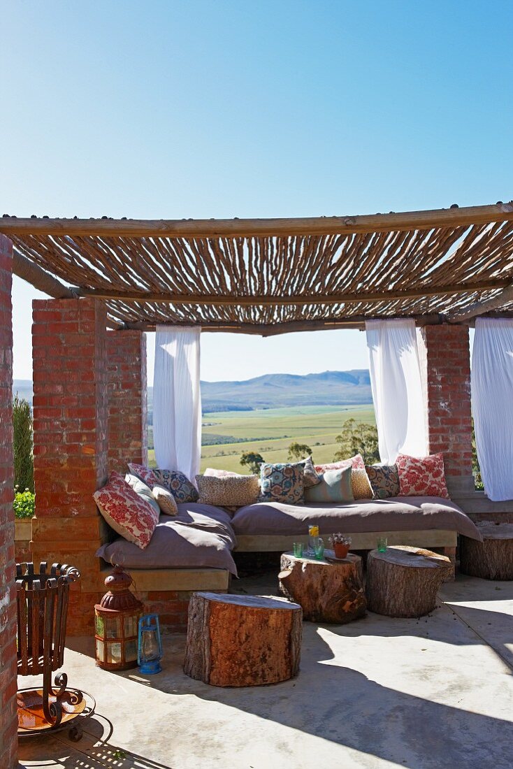 Masonry bench & tree stump tables on roof terrace with bamboo pergola on brick columns