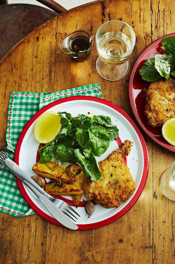 Breaded veal chops with rosemary potatoes and rocket