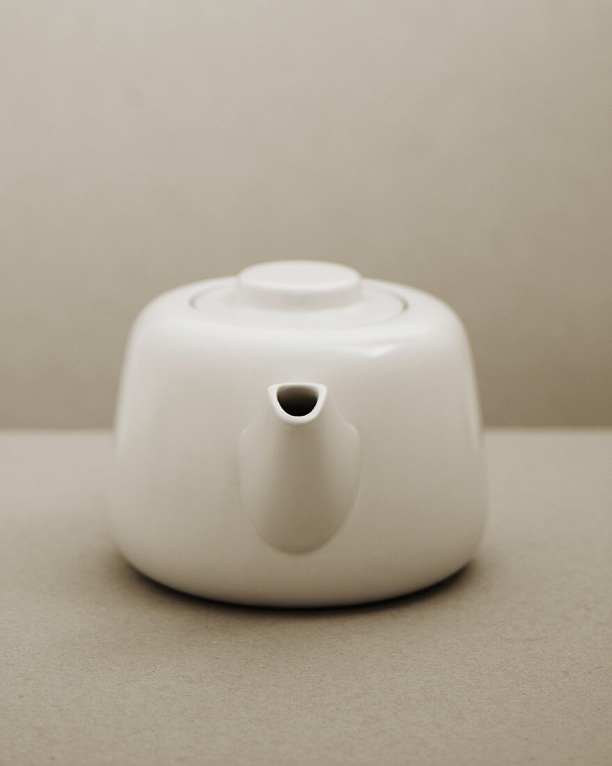 White teapot on a two-tone grey background