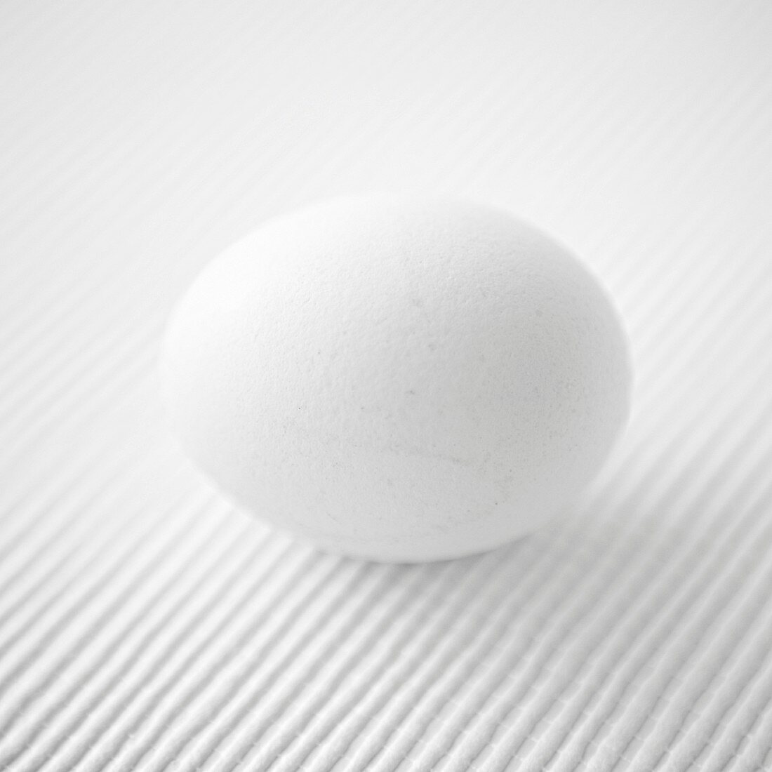 Ein weißes Ei auf weißem Untergrund