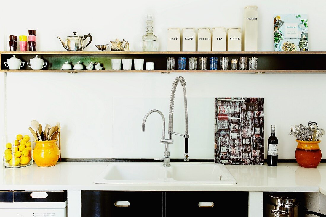 Narrow shelf and retro-look kitchen fronts as structural black elements in white kitchen