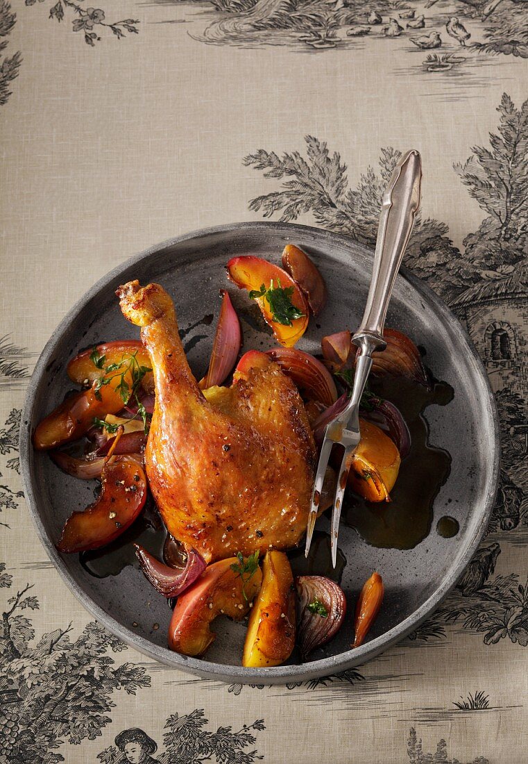 Roasted duck leg with apples and onions