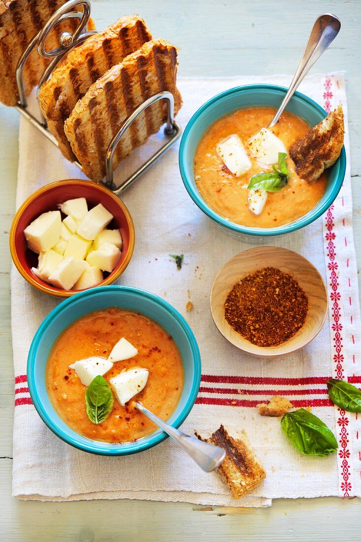 Cold yellow tomato soup with mozzarella and toast