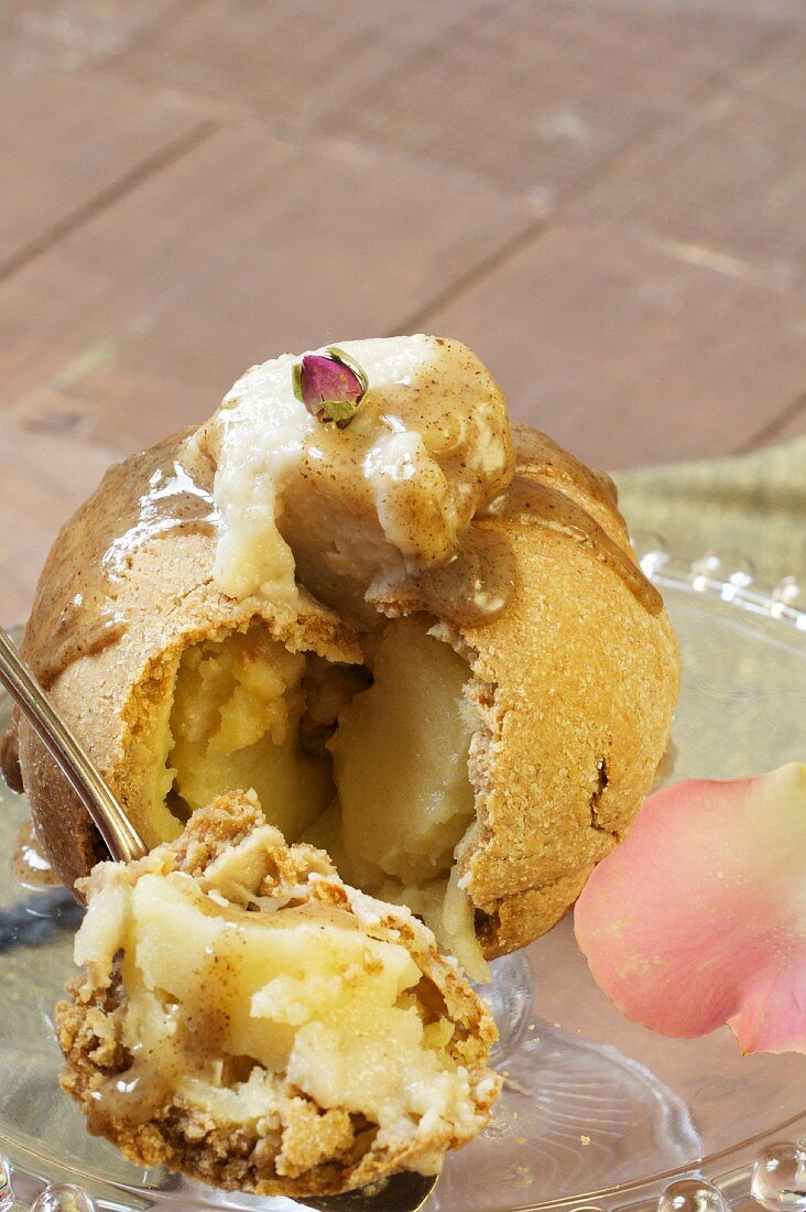 An apple wrapped in pastry with vanilla cream and caramel sauce