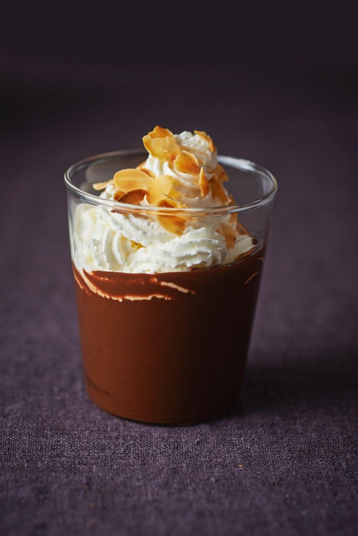Mousse au chocolat topped with whipped cream and toasted almonds