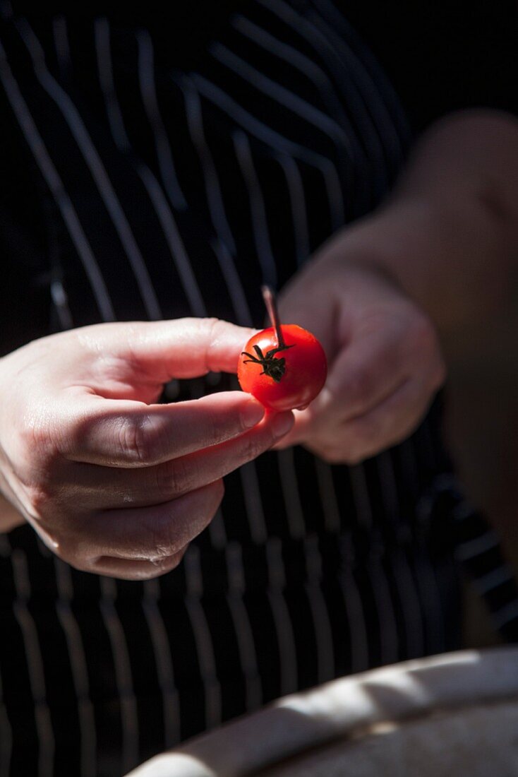 A tomato being skewered