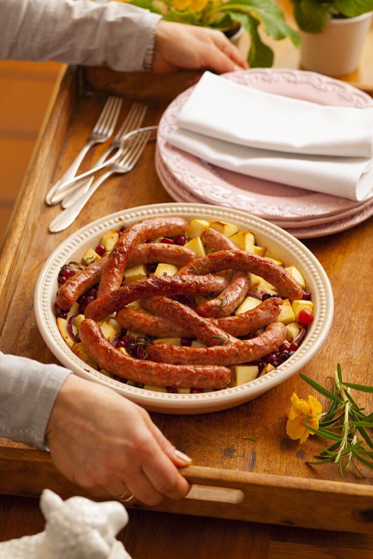 Sausages on fried potatoes with cranberries