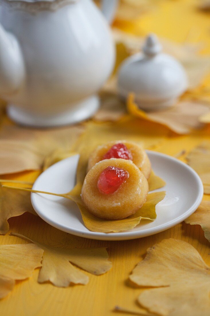 Mini sponge cakes with glacé cherries on gingko leaves