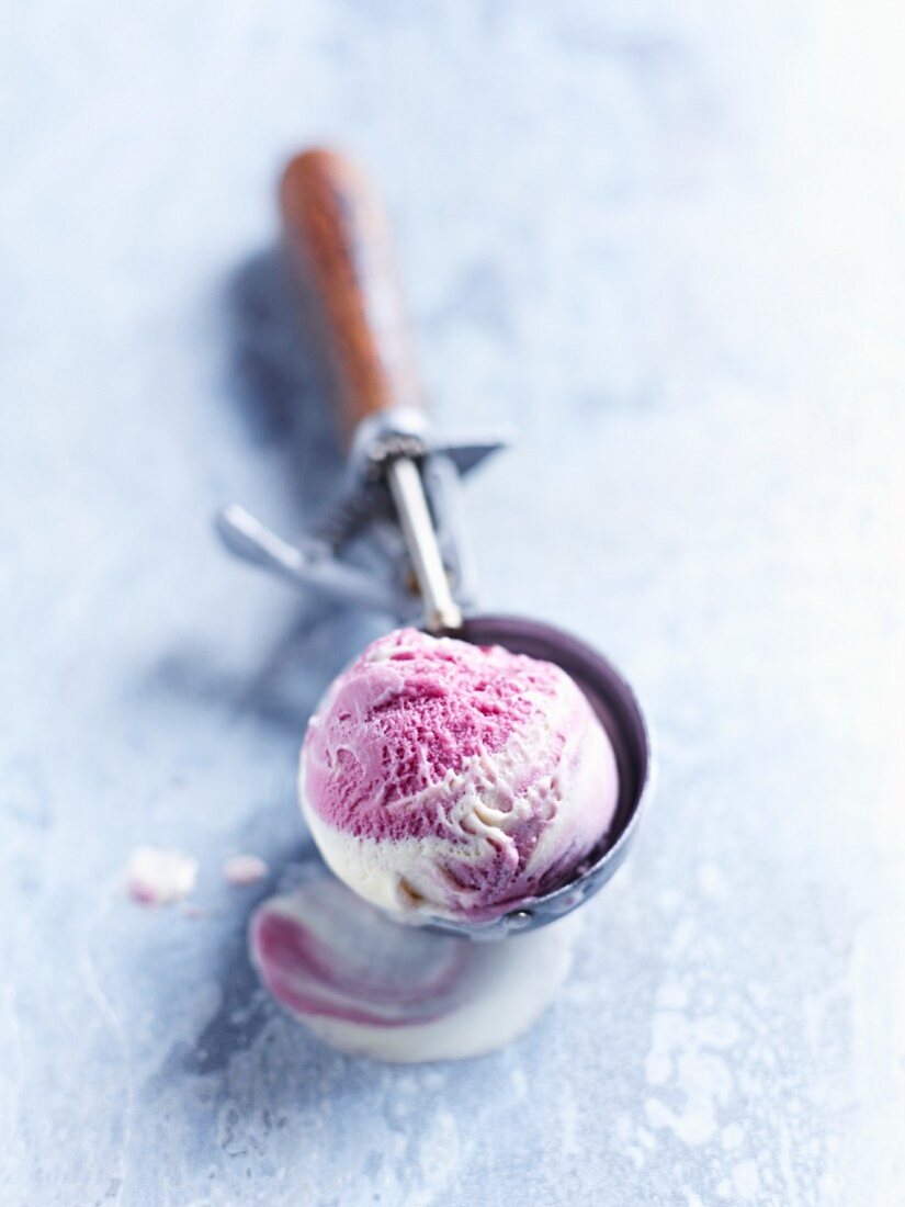 A scoop of blueberry ice cream in an ice cream server