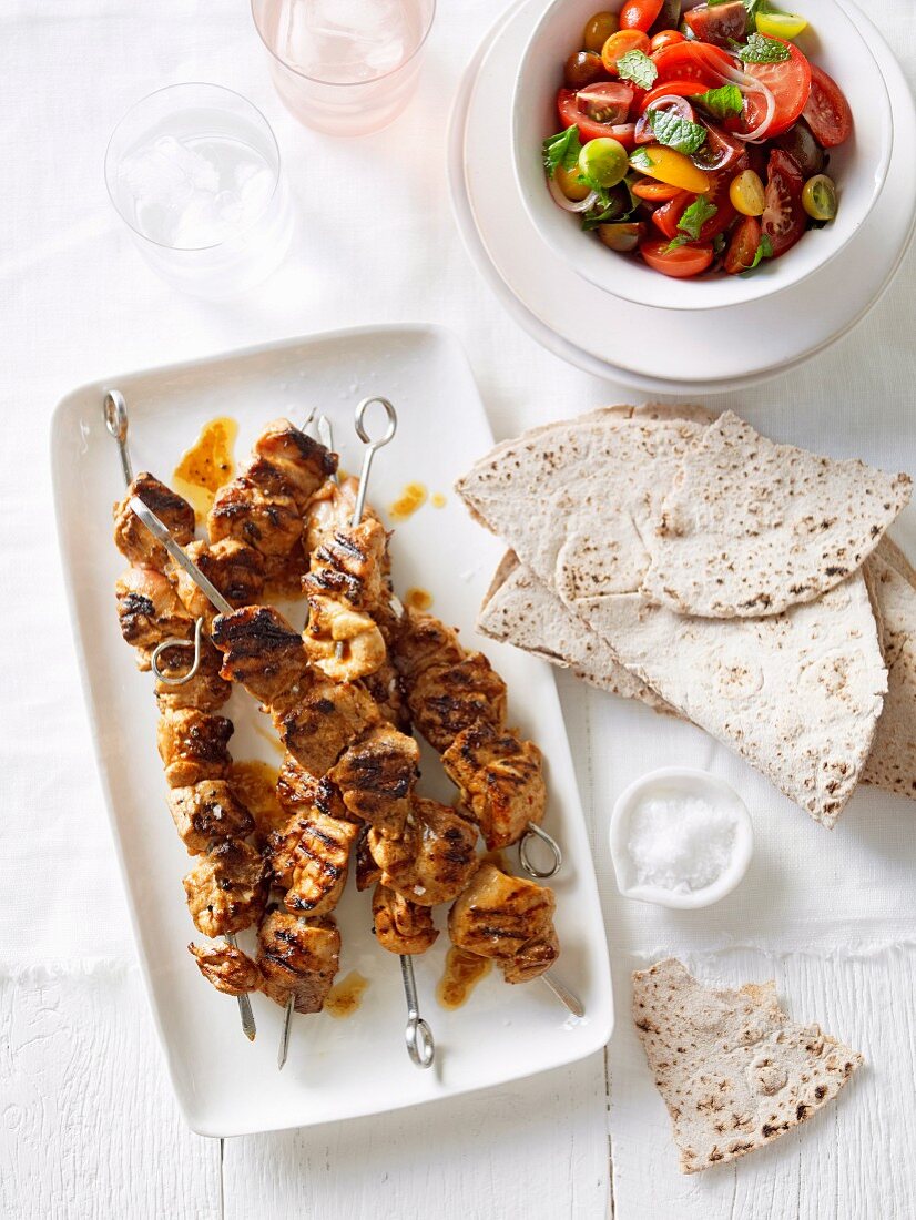 Chicken skewers with a tomato salad and flatbread (Portugal)