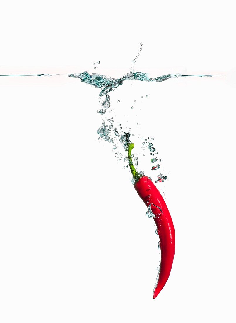A red chilli pepper falling into water
