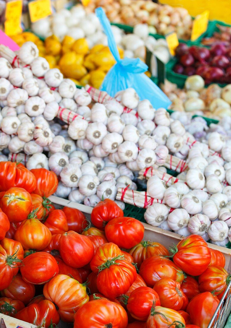 Marktstand mit Tomaten, Knoblauch, Zitronen und Zwiebeln