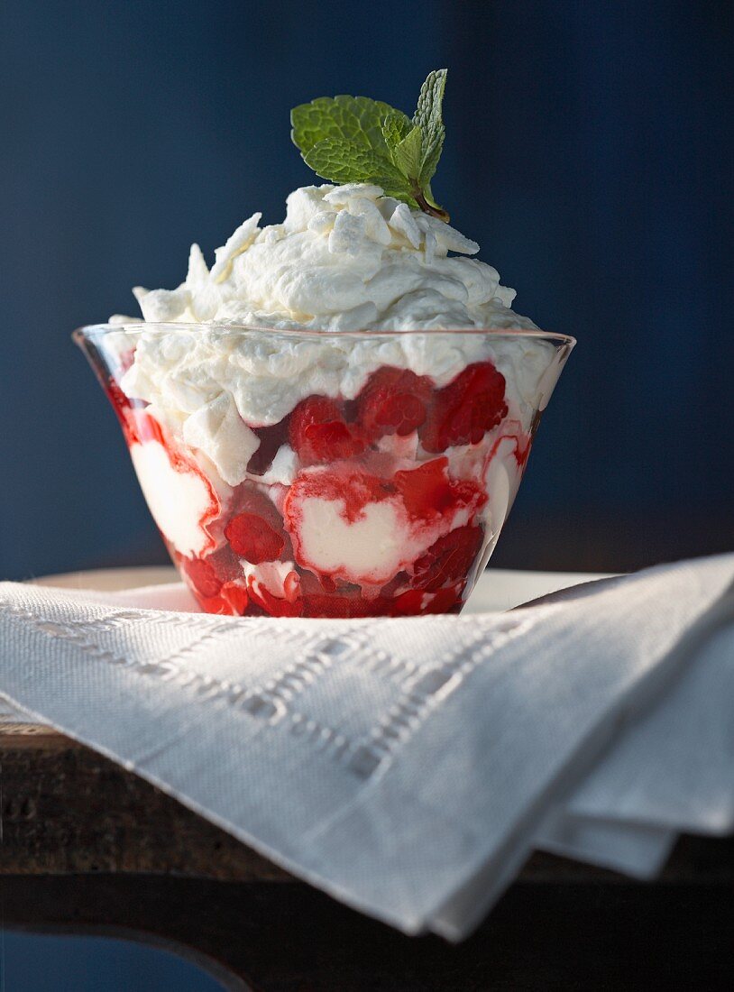 A layered dessert with raspberries and meringue