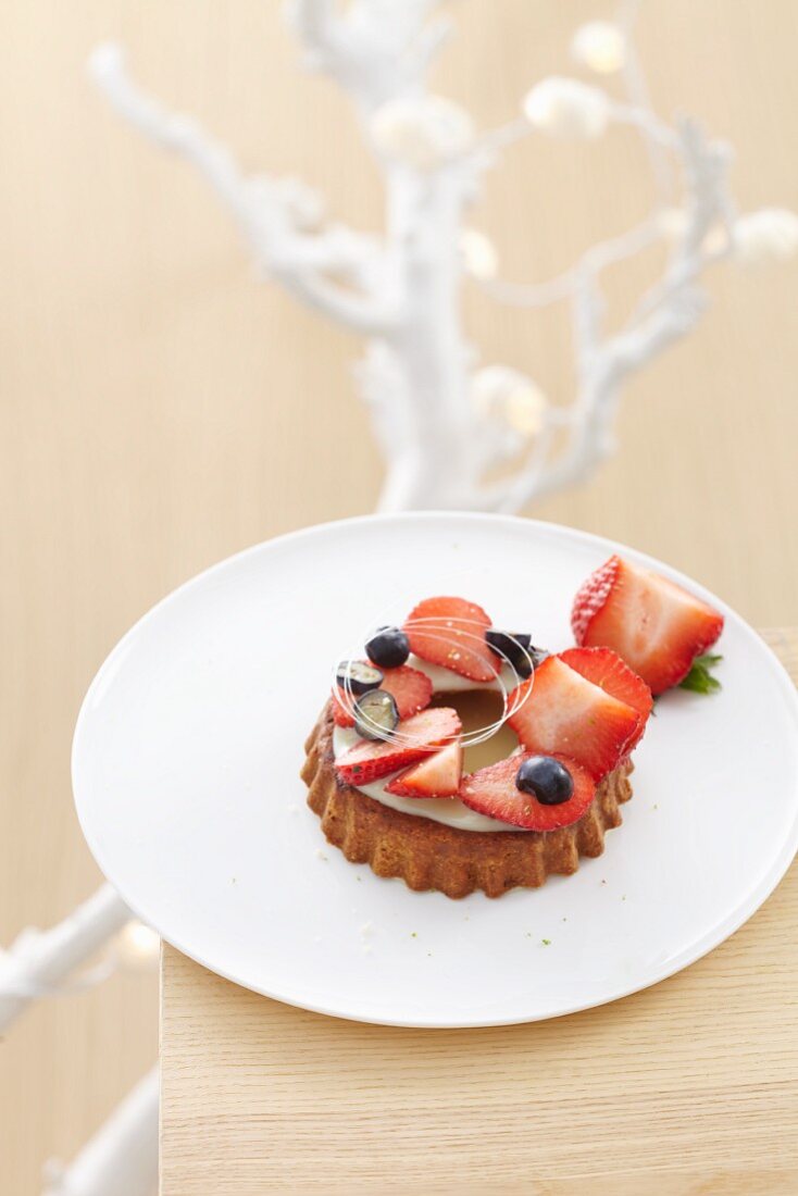 Individual white chocolate torte topped with strawberries and blueberries