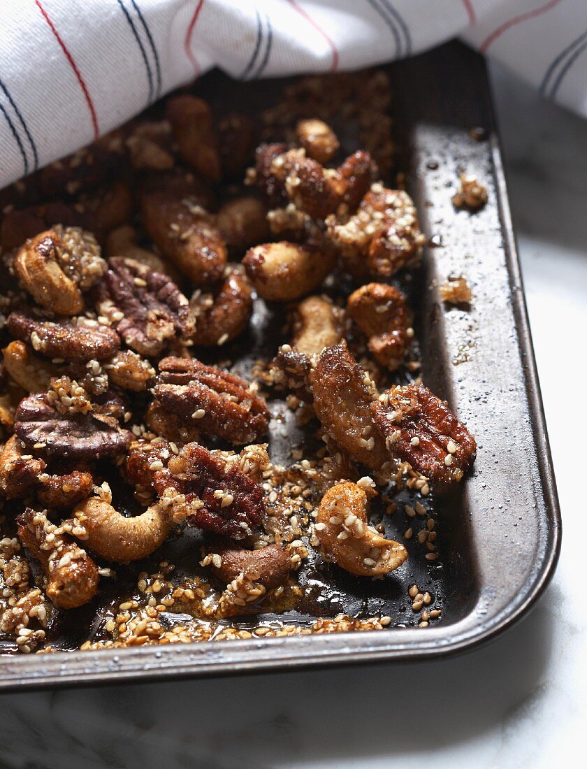 Caramelised nuts with sesame seeds on a baking tray