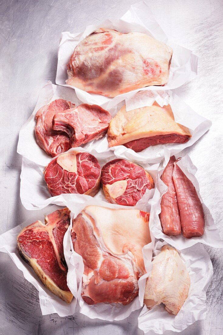 Verschiedene Fleischsorten und Hühnerbrust auf Papier