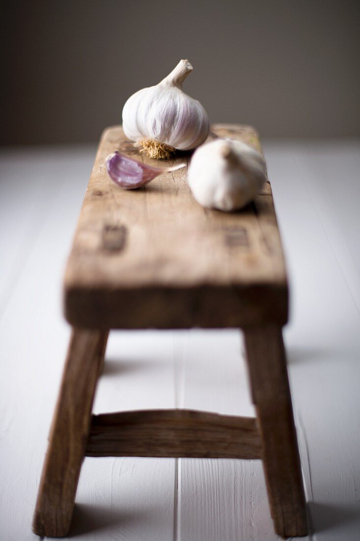 Fresh garlic bulbs on a wooden stool