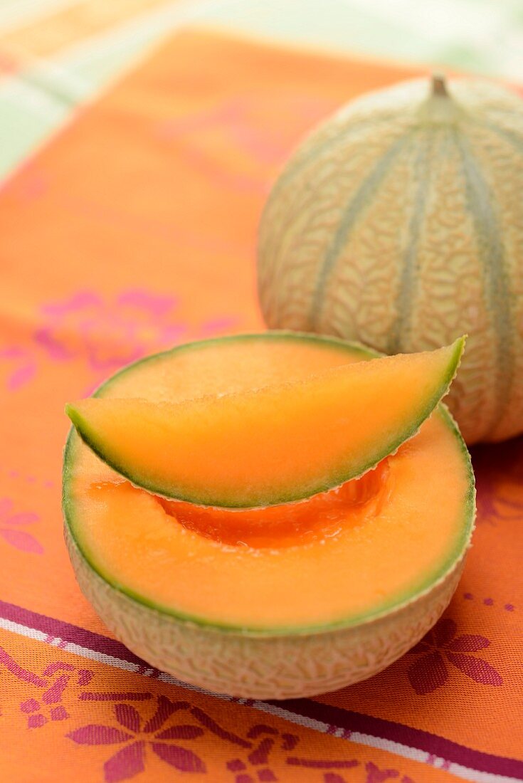 Cantaloupemelonen, ganz, halbiert und Spalte
