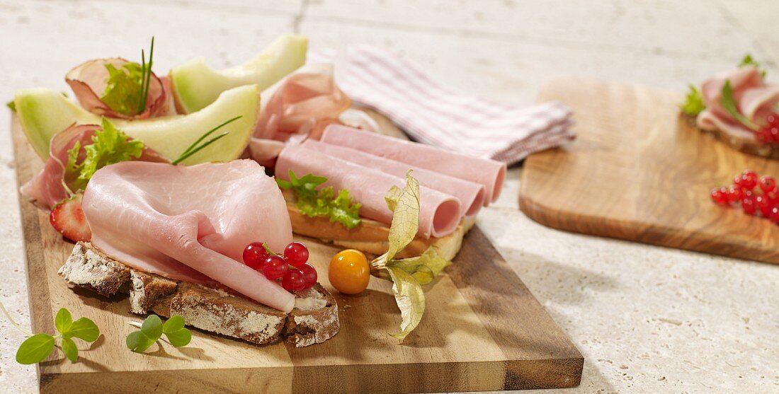 Slices of bread with cold meats and melon wedges