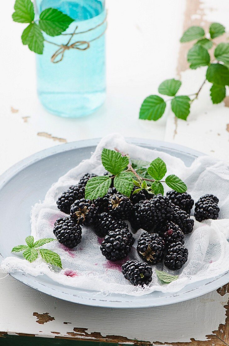 Fresh blackberries with a muslin cloth on a plate