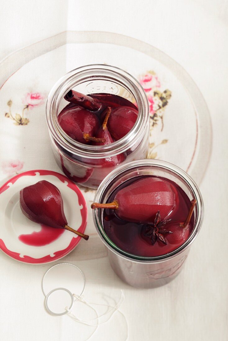 Pears in red wine with spices in preserving jars