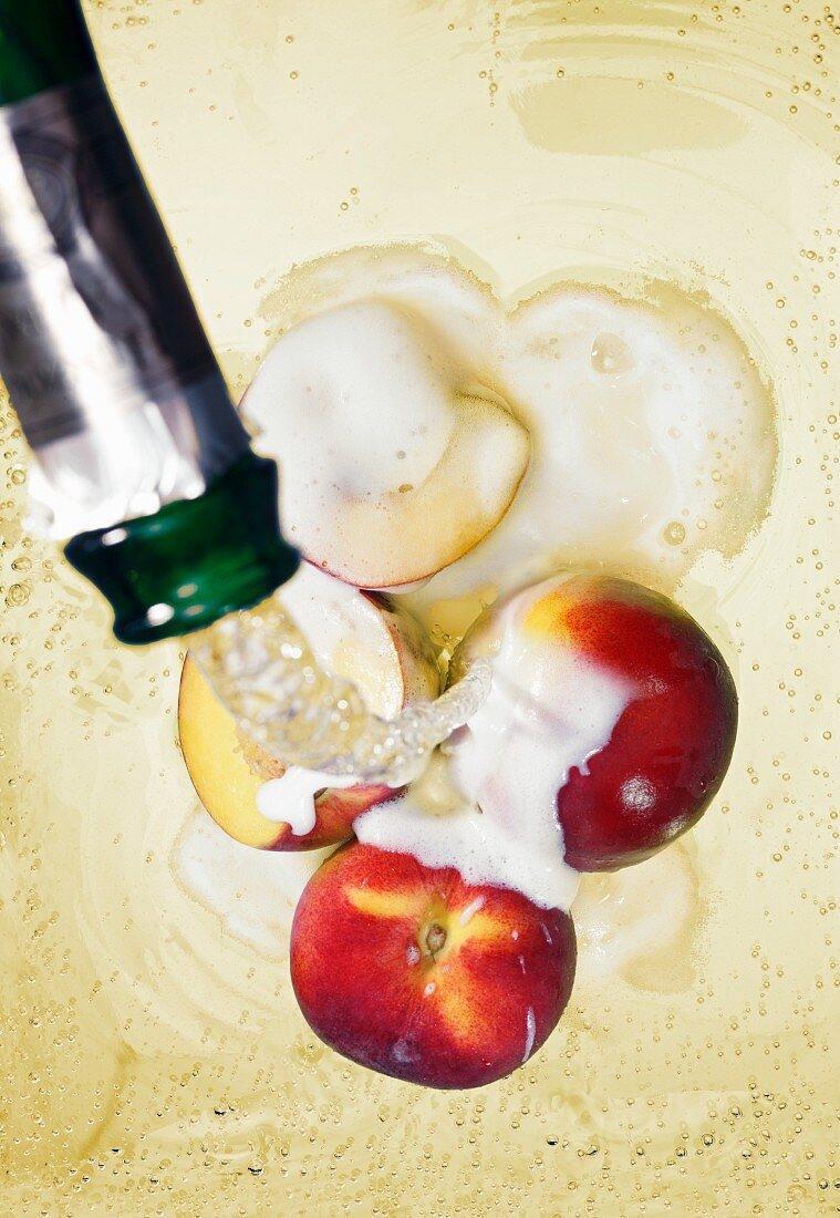 Sparkling wine being poured over peaches