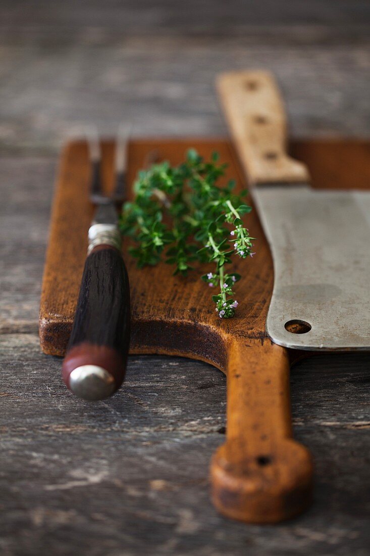 Thyme with a Carving Fork and Knife on a Cutting Board