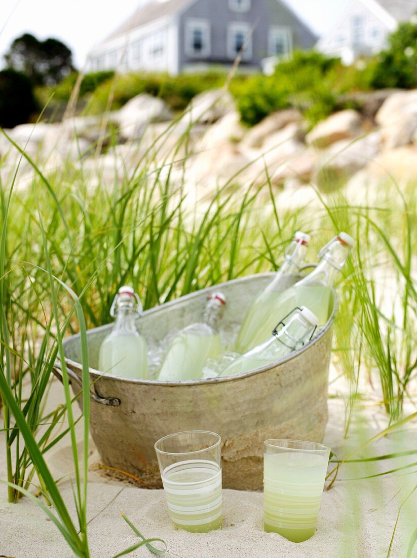 Bottles of Lemonade in an Ice Bucket on the Beach