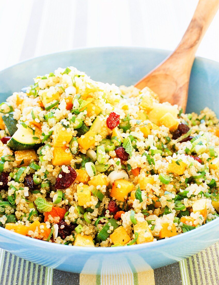 Bowl of Quinoa Salad with a Wooden Spoon
