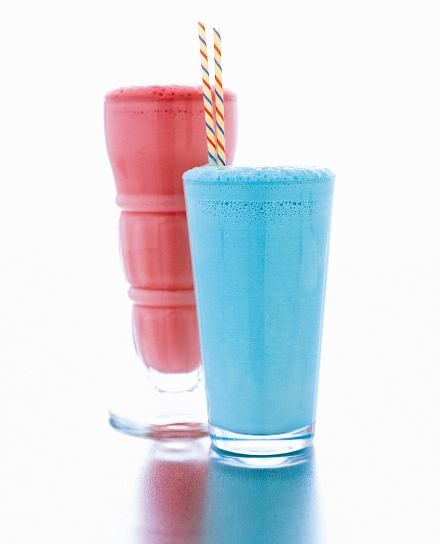 Ein roter & ein blauer Milchshake in Gläsern mit Strohhalm