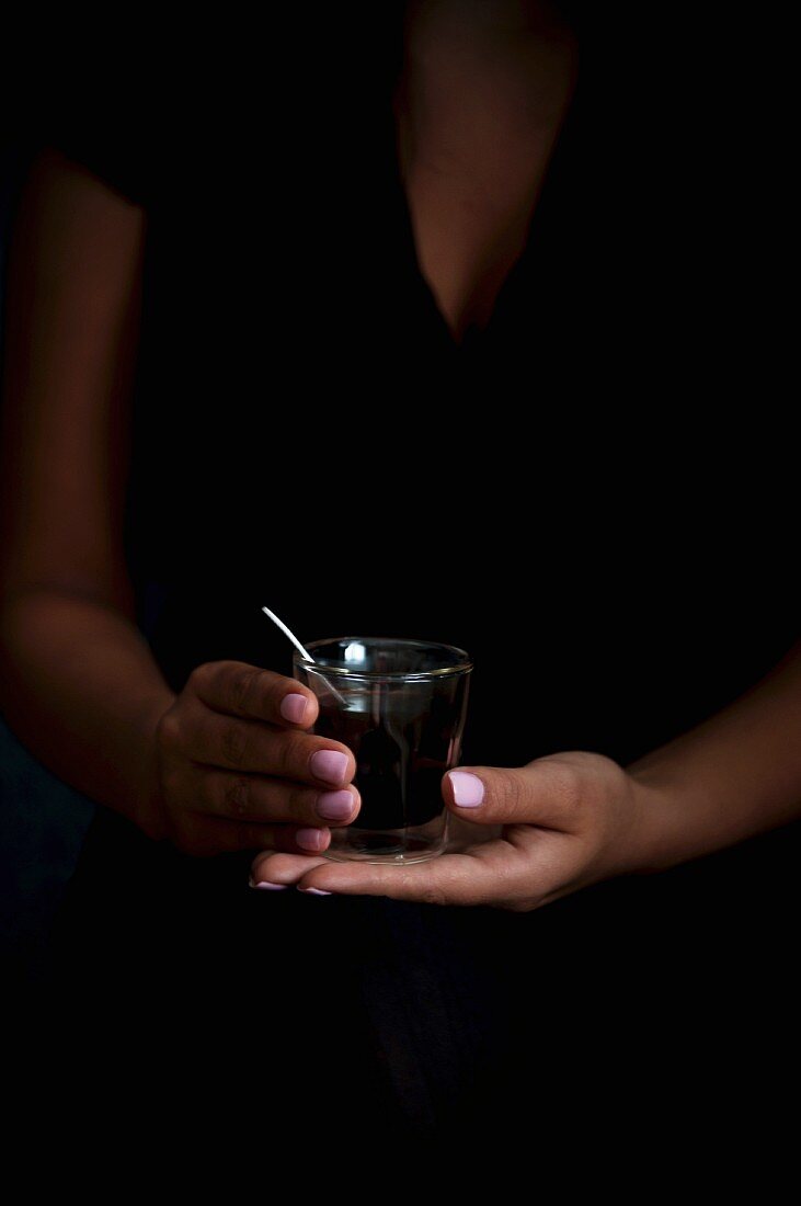 A woman holding a glass of coffee