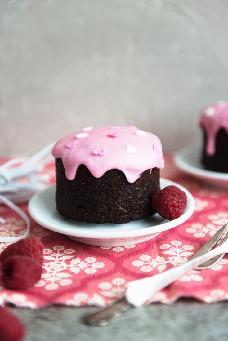 Small treacle pudding with raspberry icing and raspberries