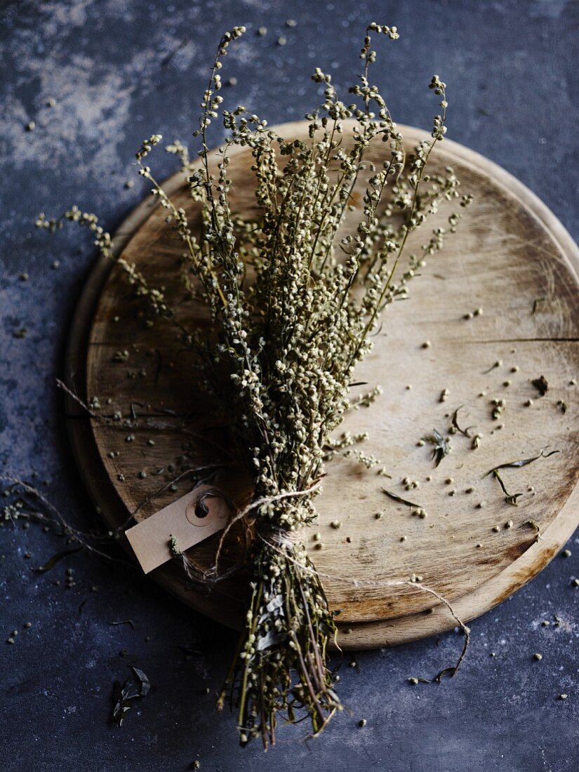 Dried mugwort, tied in a bunch with a label, on a wooden plate