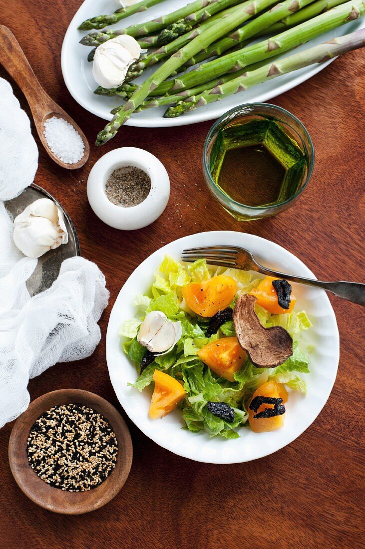 A still life featuring ingredients for salad and for an asparagus dish (view from above)