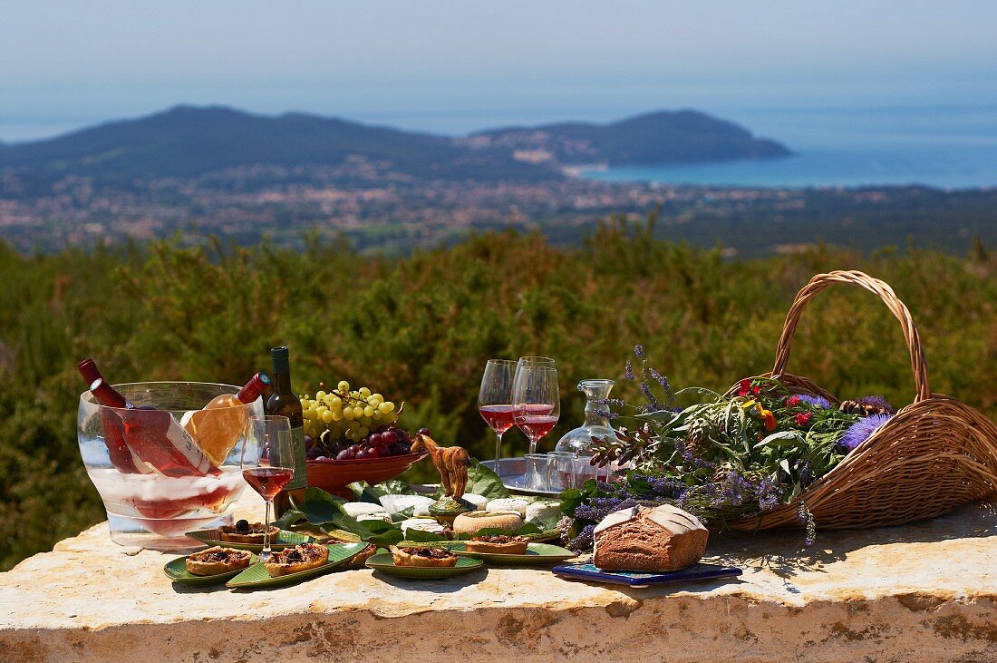 Gedeckter Tisch mit Brot, Käse, Trauben und Wein in der Region Domaine De La Begude, Südfrankreich