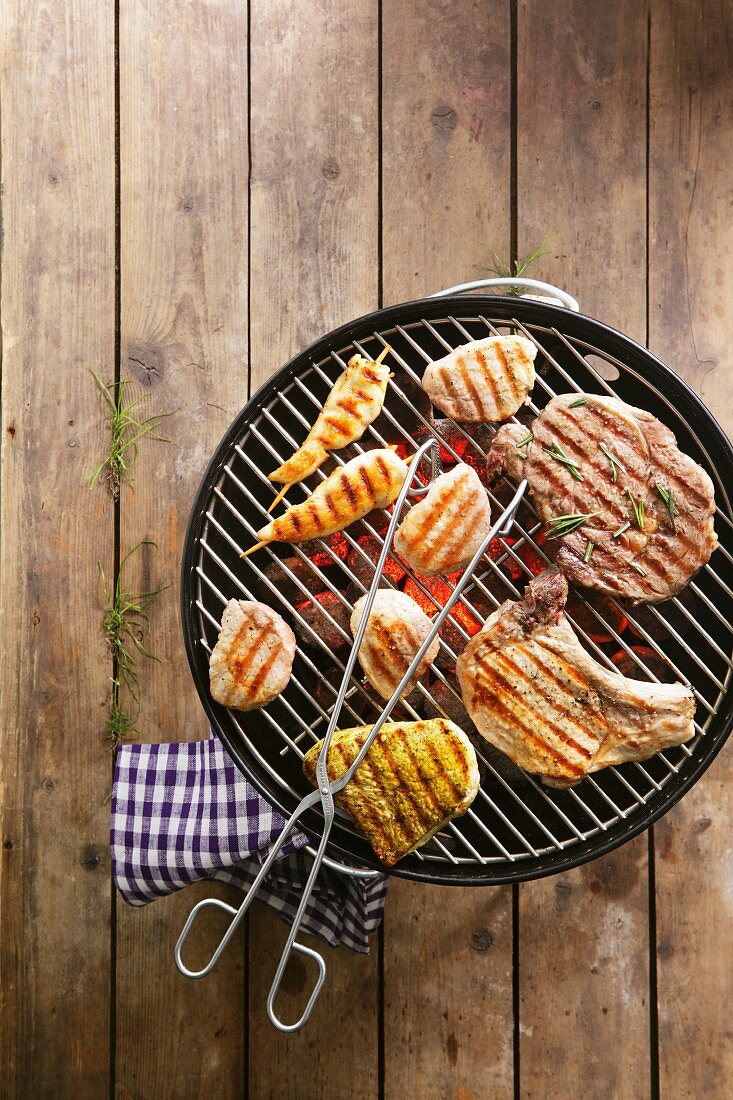 Barbecued meat and chicken skewers on the barbecue grill