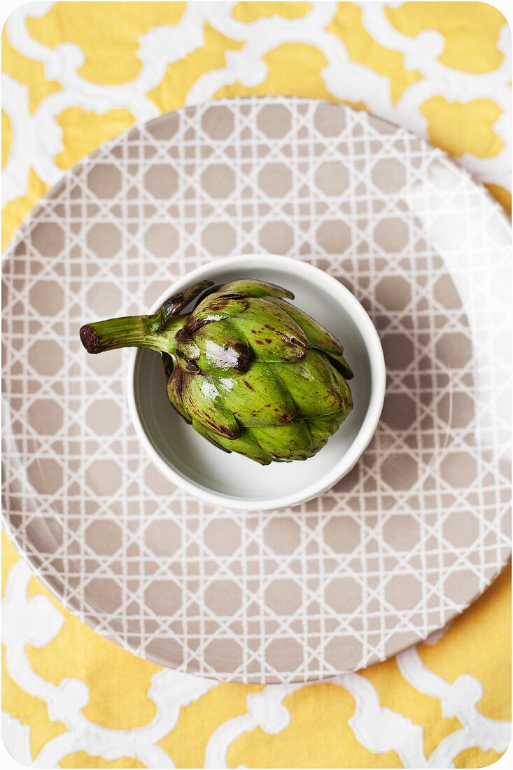Baby Artichoke in a White Bowl on a Patterned Plate