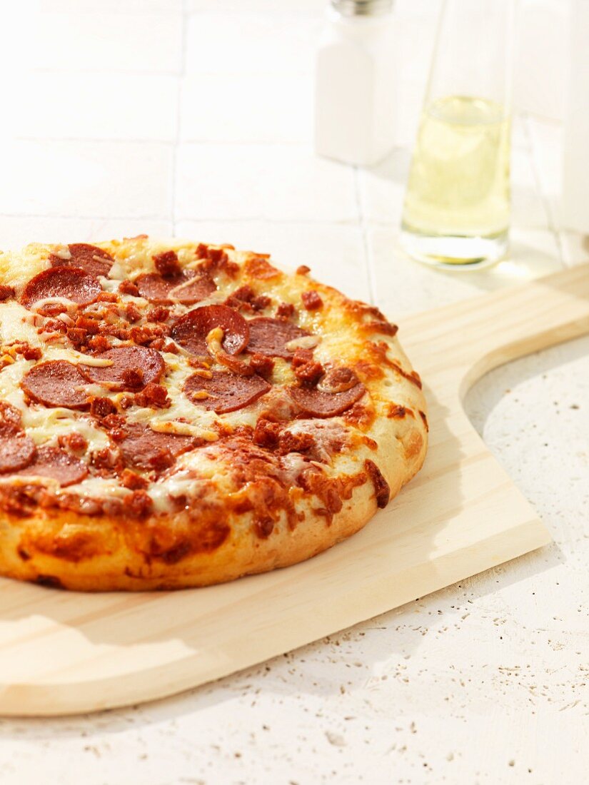 Pizza mit Peperoniwurst auf Schneidebrett