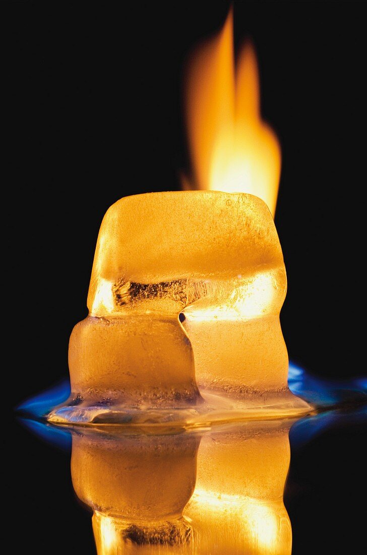 A burning ice-cube against a black background