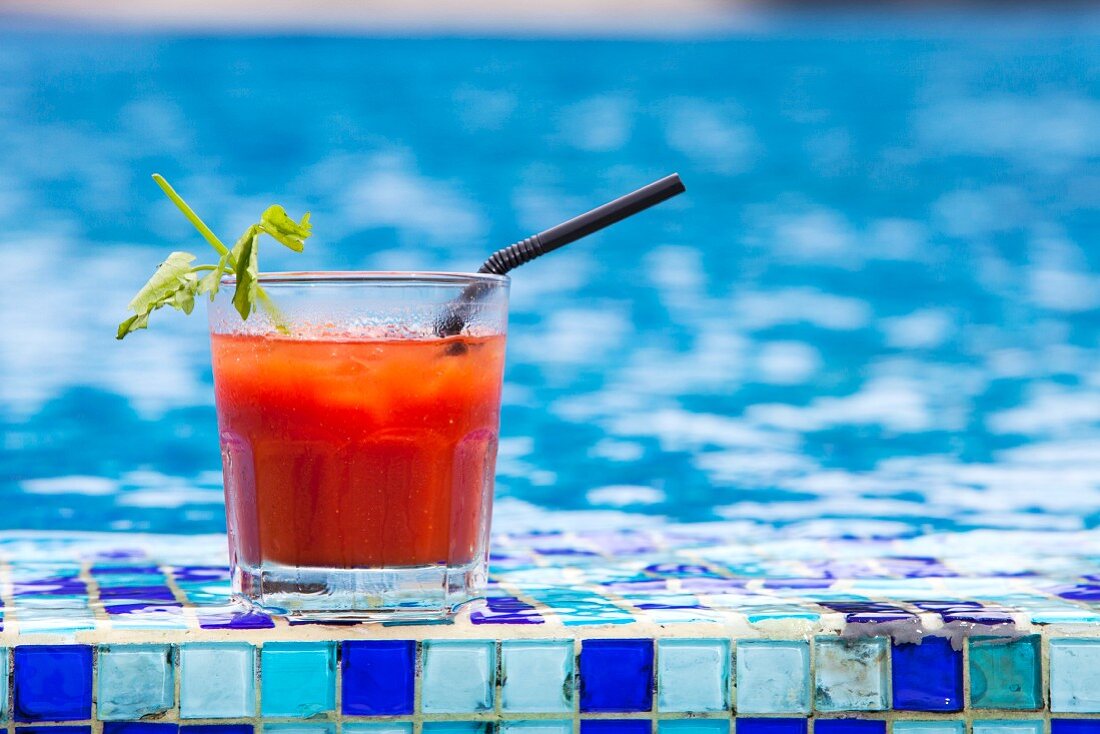 A Bloody Mary cocktail by a swimming pool