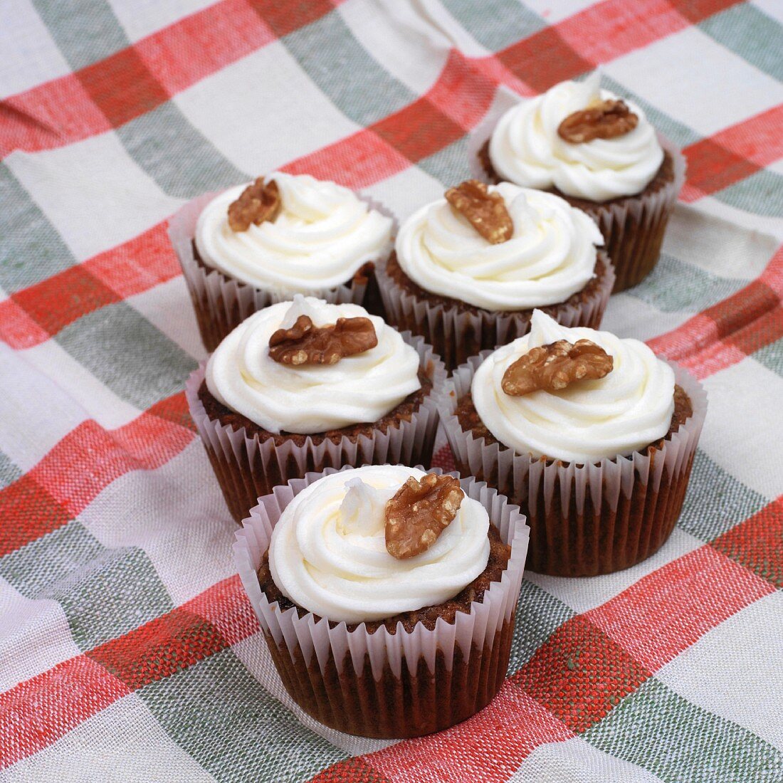Cupcakes topped with icing and walnuts