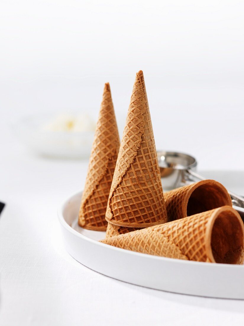 Several ice cream cones in front of an ice cream scoop
