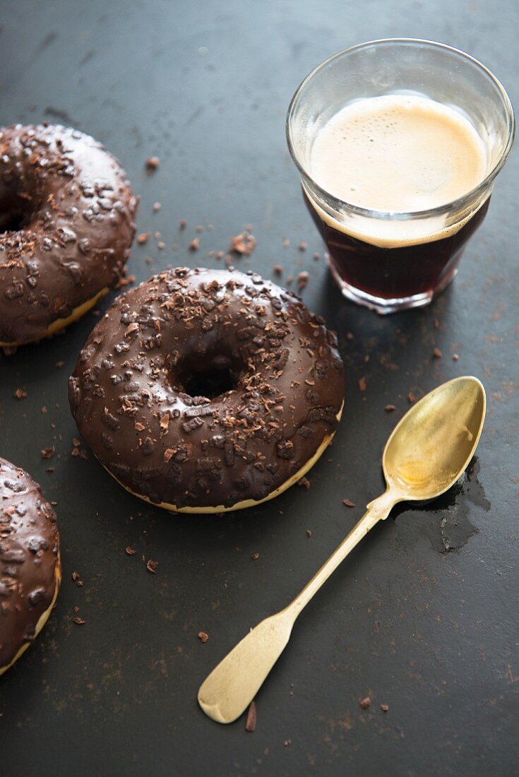Chocolate doughnuts served with coffee in a glass