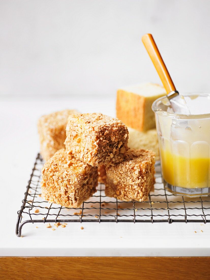 Lemon and almond lamingtons on a cooling rack