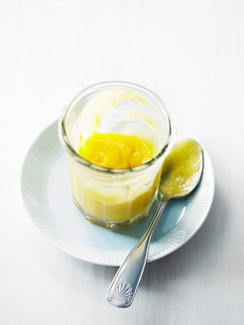 Lemon curd in a glass with a spoon